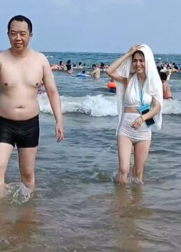 海边美女顶着衣服玩水